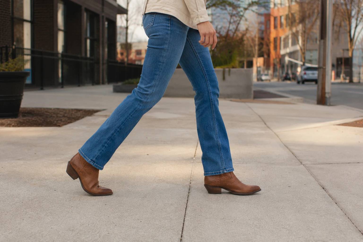 Santiags Ariat femme marron portées en ville avec un jean
